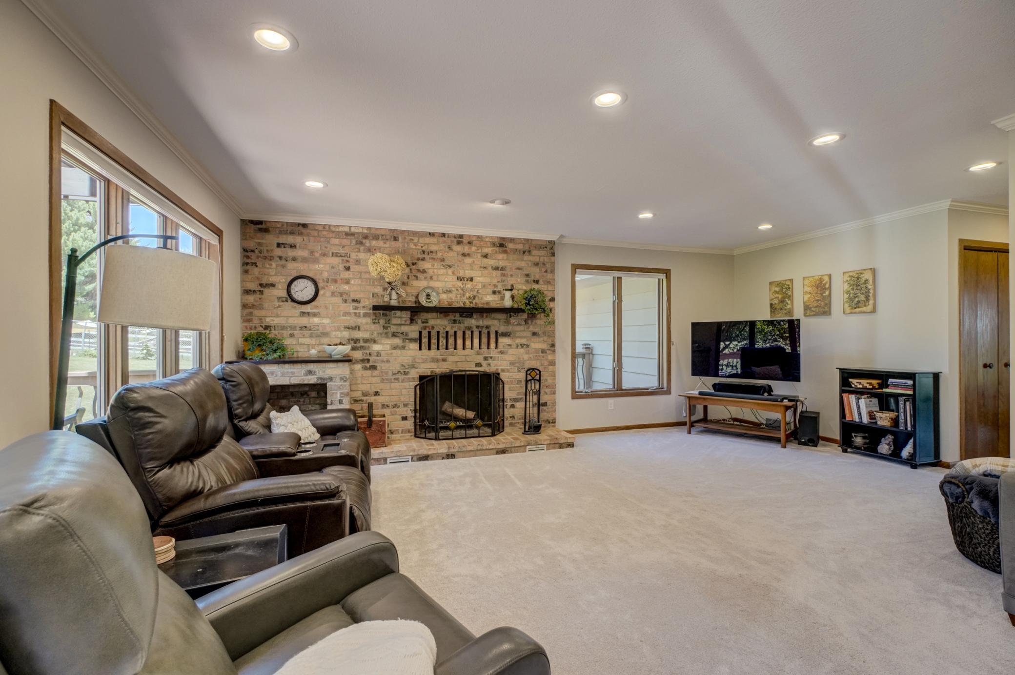 Unwind in the inviting living room centered around a classic wood-burning brick fireplace