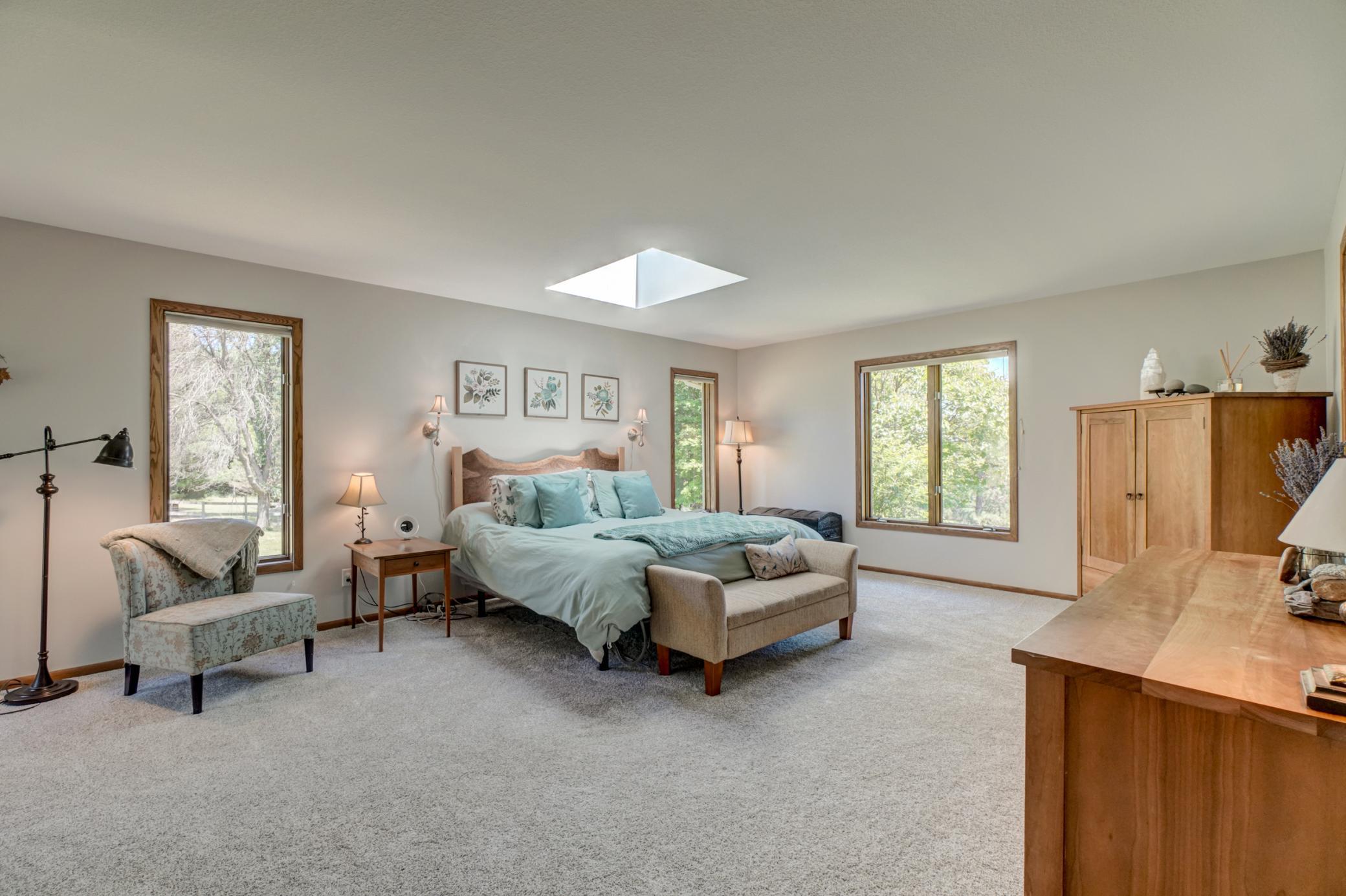 The main-level primary suite is a true retreat with a private deck overlooking the pasture, new carpet, and a beautifully remodeled spa-inspired bathroom