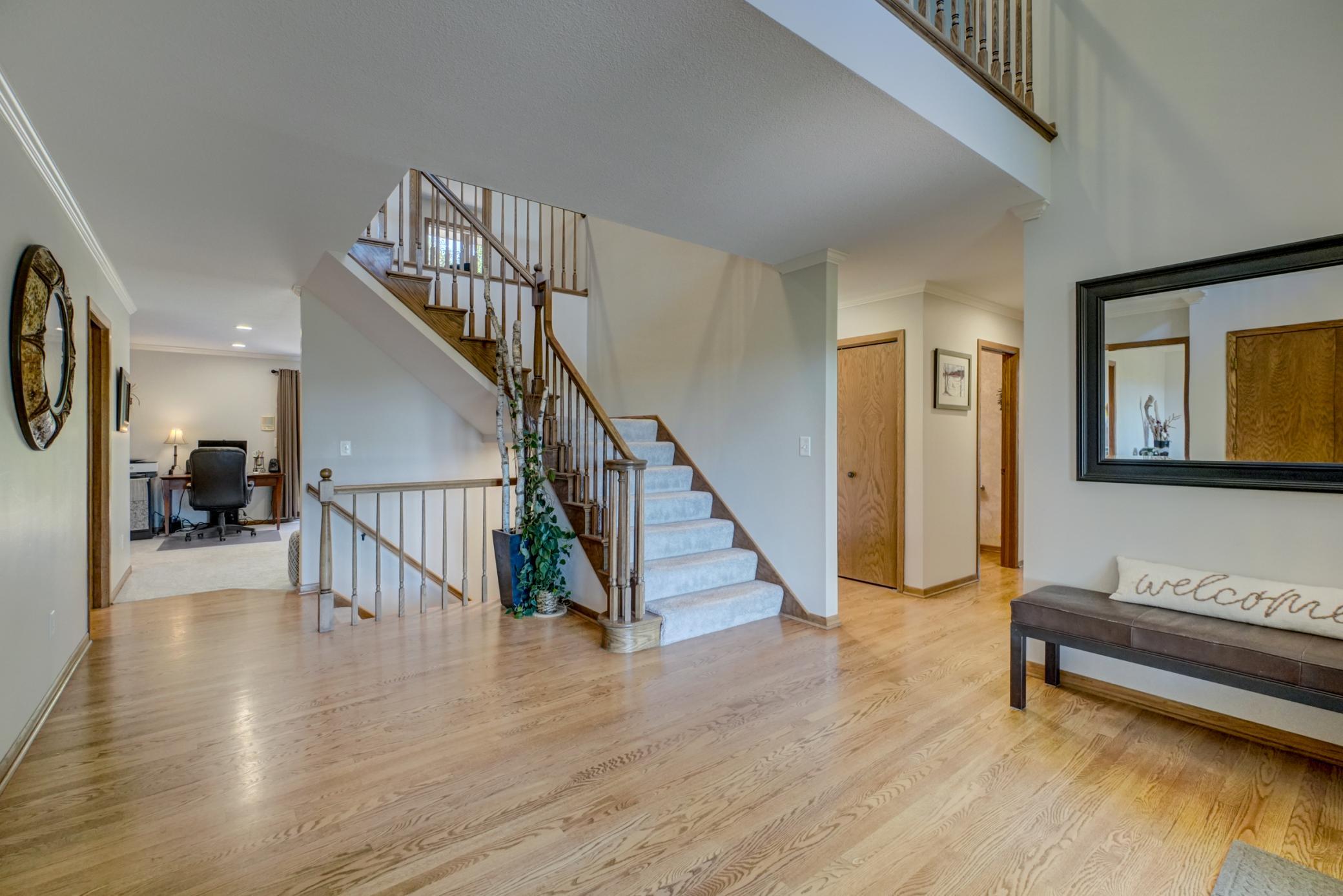 This spacious foyer welcomes you with soaring ceilings, filling the home with bright natural light