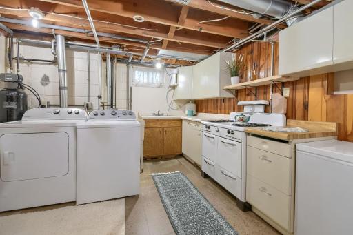 Say what!? Check out this lower level kitchenette with the laundry area! Gas stove, deep freezer, full refrigerator. (You HAVE to come open the cabinets for a cool surprise!)