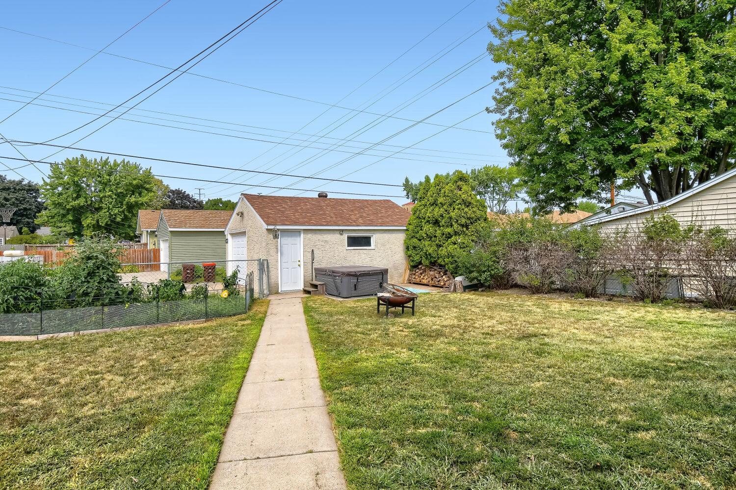 Fully fenced backyard is hot tub ready and features established gardens.