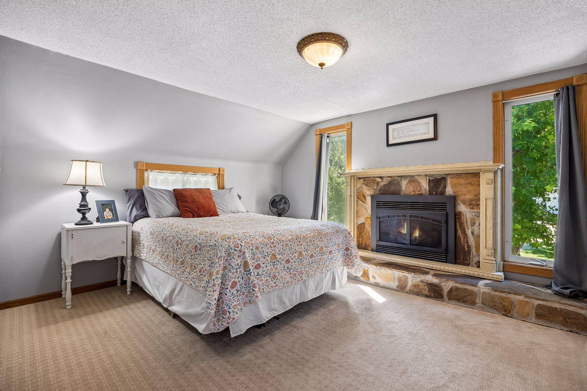 Previously the primary bedroom, it's got a cozy gas fireplace and floor-to-ceiling windows