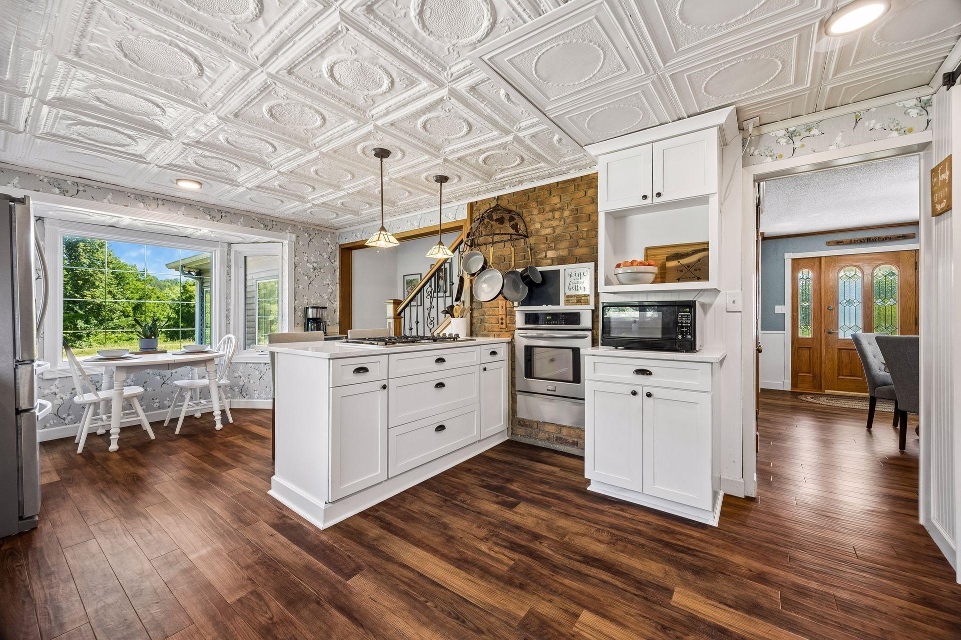 The white cabinetry and tin ceilings make the kitchen feel very bright