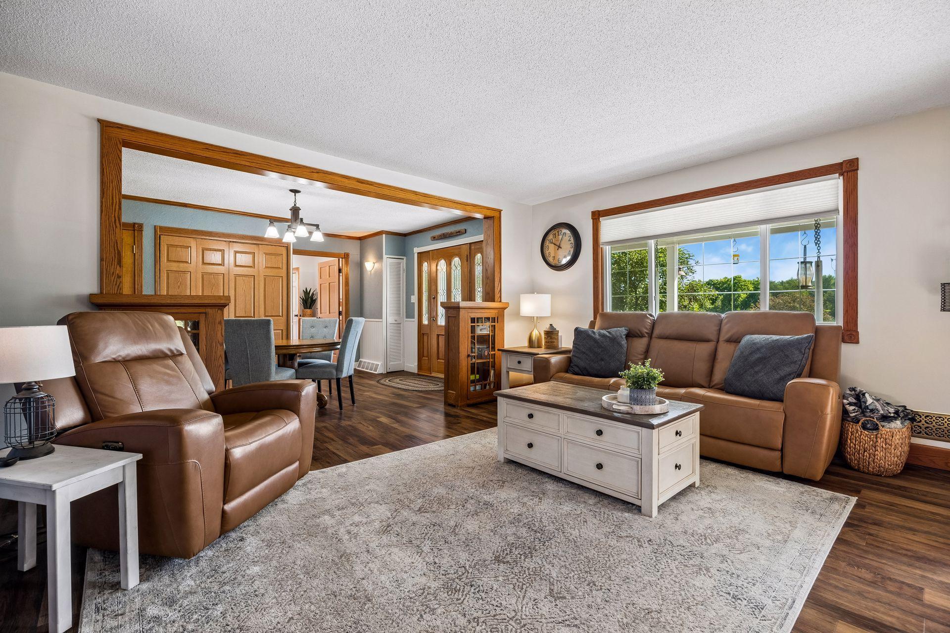 Shown is the living room, formal dining room, and beyond that is the main level primary suite