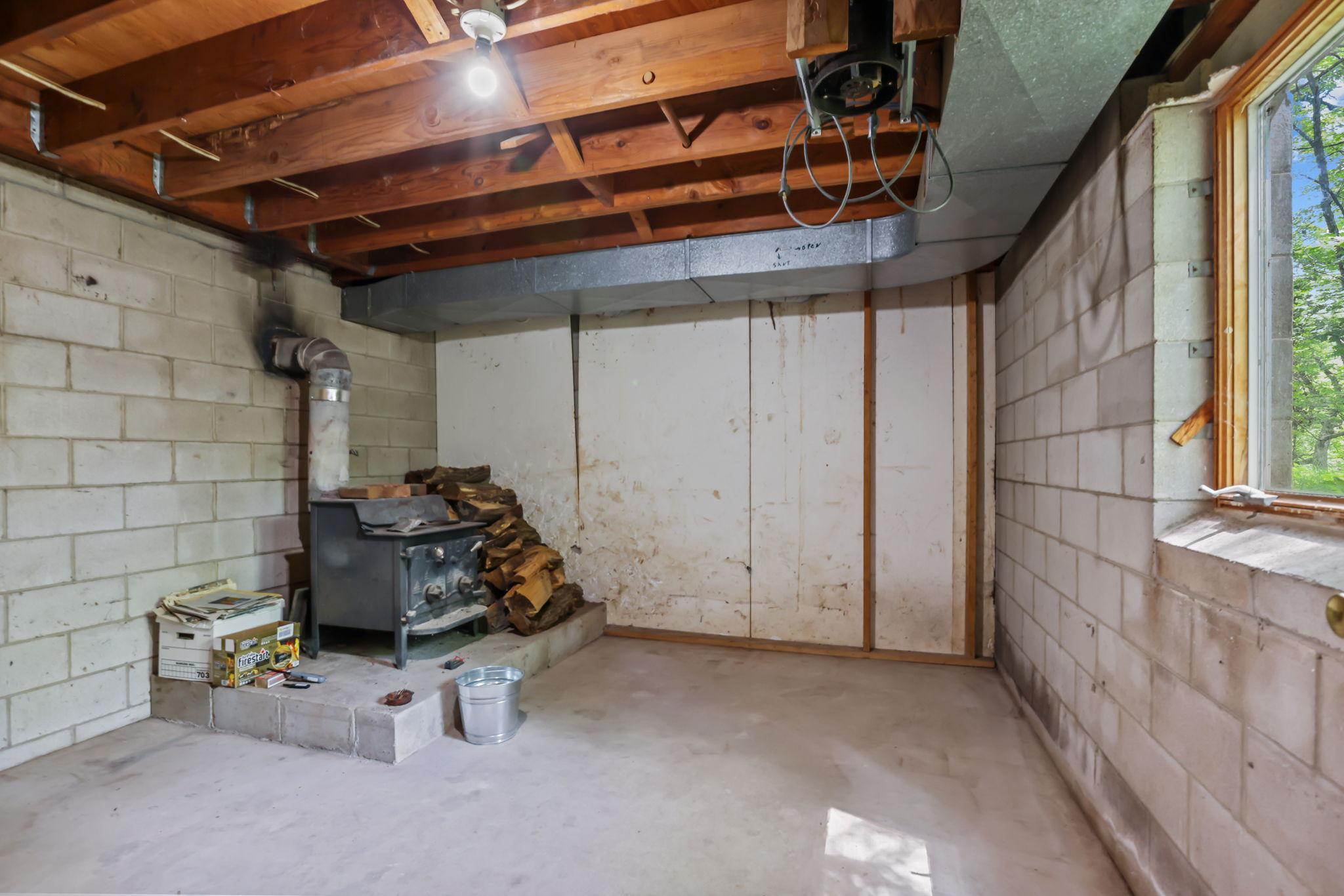 Basement bonus room features wood stove which helps heat the home.