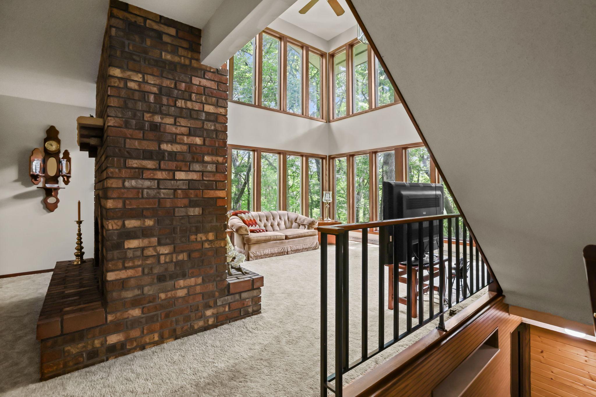 Upstairs leads to 2-story Living room with walls of windows.