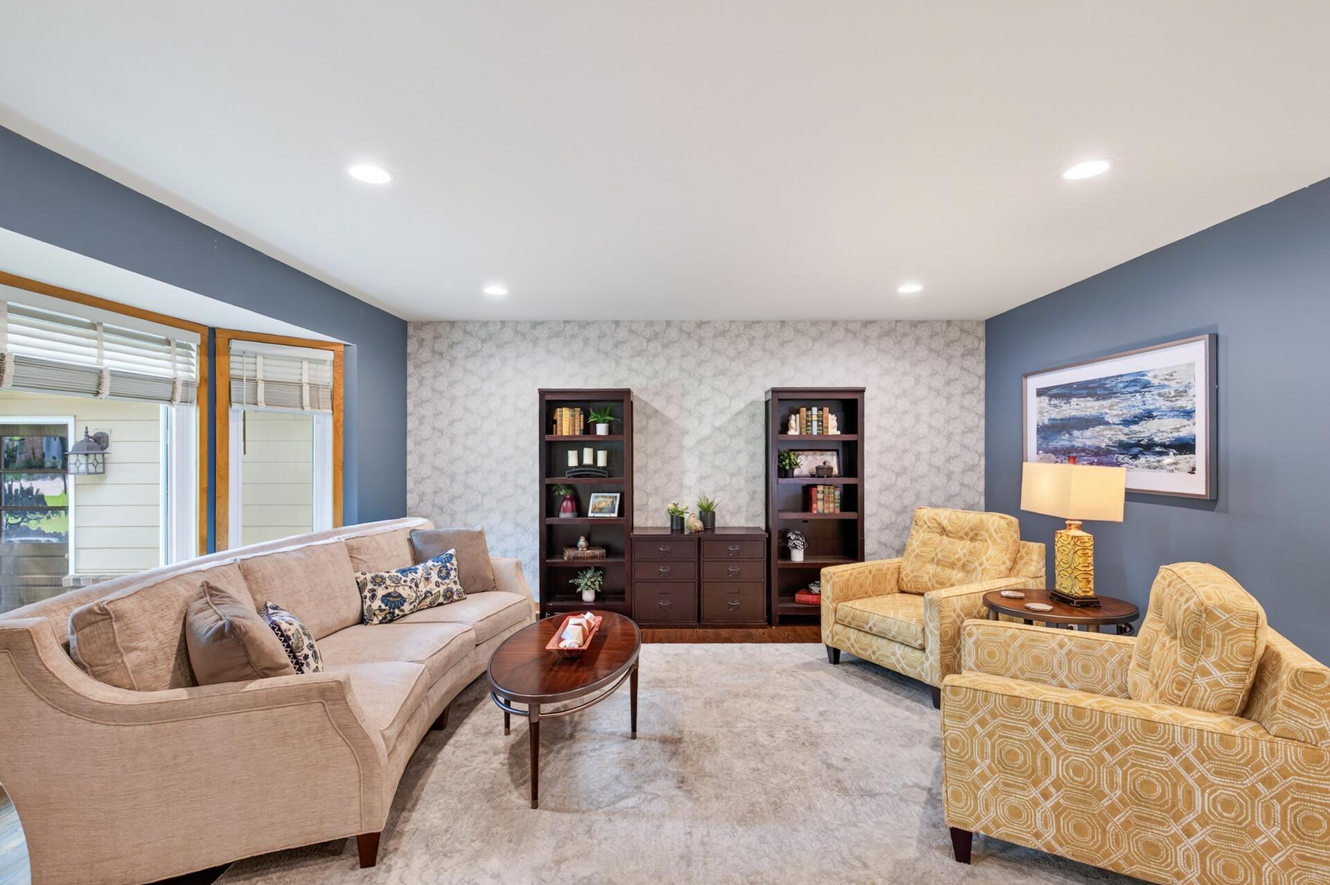 The spacious main floor living room features a bay window, hardwood flooring and is tastefully designed.
