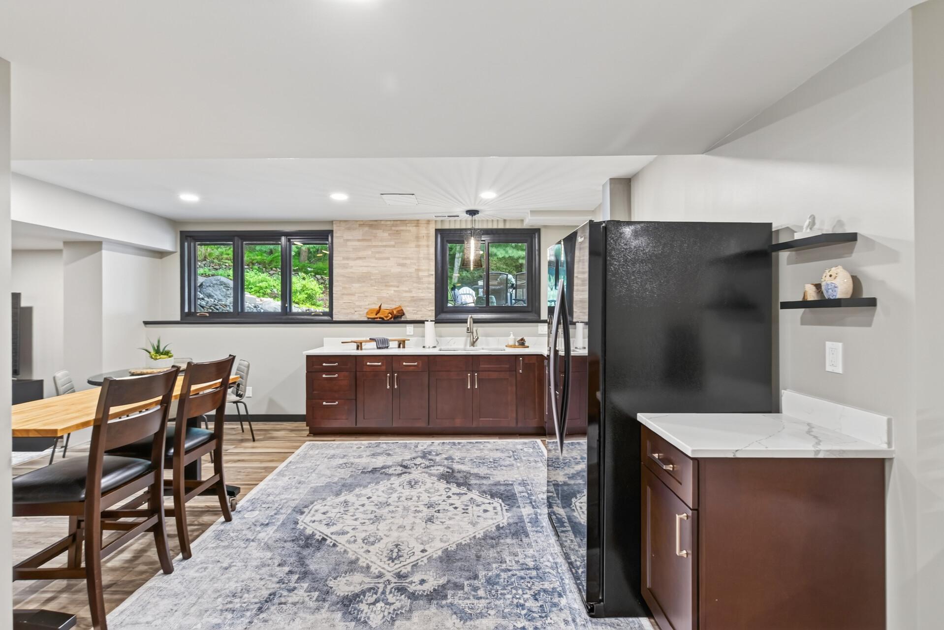 Quartz countertops, abundant cabinetry, and generous workspace make the lower level second kitchen both stylish and functional.