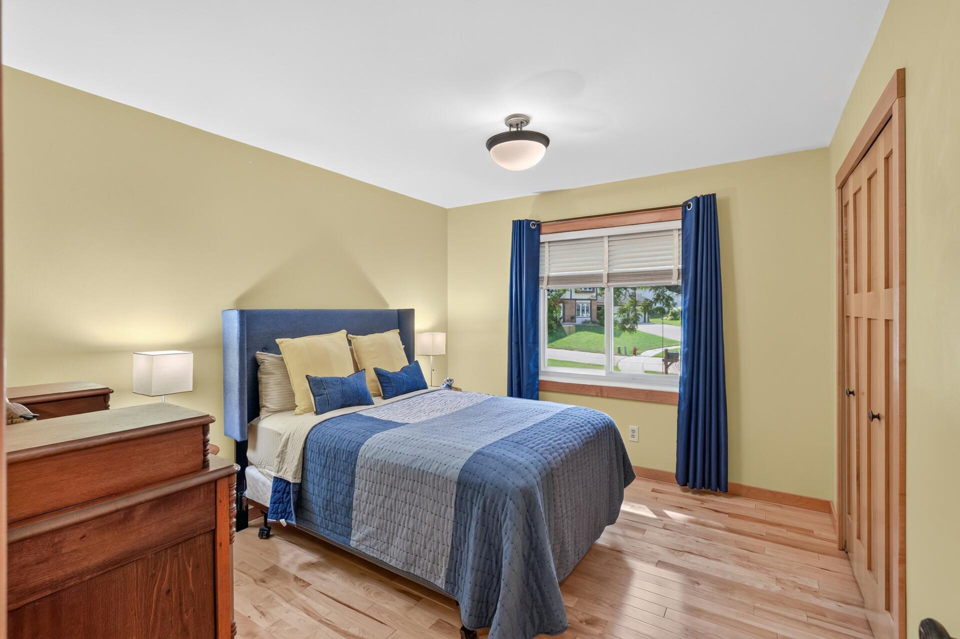 A second spacious upper-level bedroom with hardwood flooring and abundant natural light.