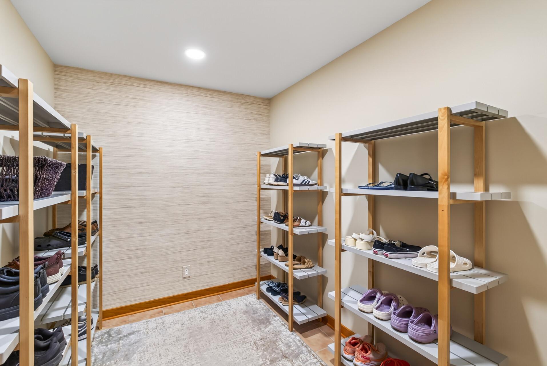 This dedicated shoe room and storage room helps keep everything organized and out of sight. It also has plumbing and drain nearby for converting to a main floor laundry.