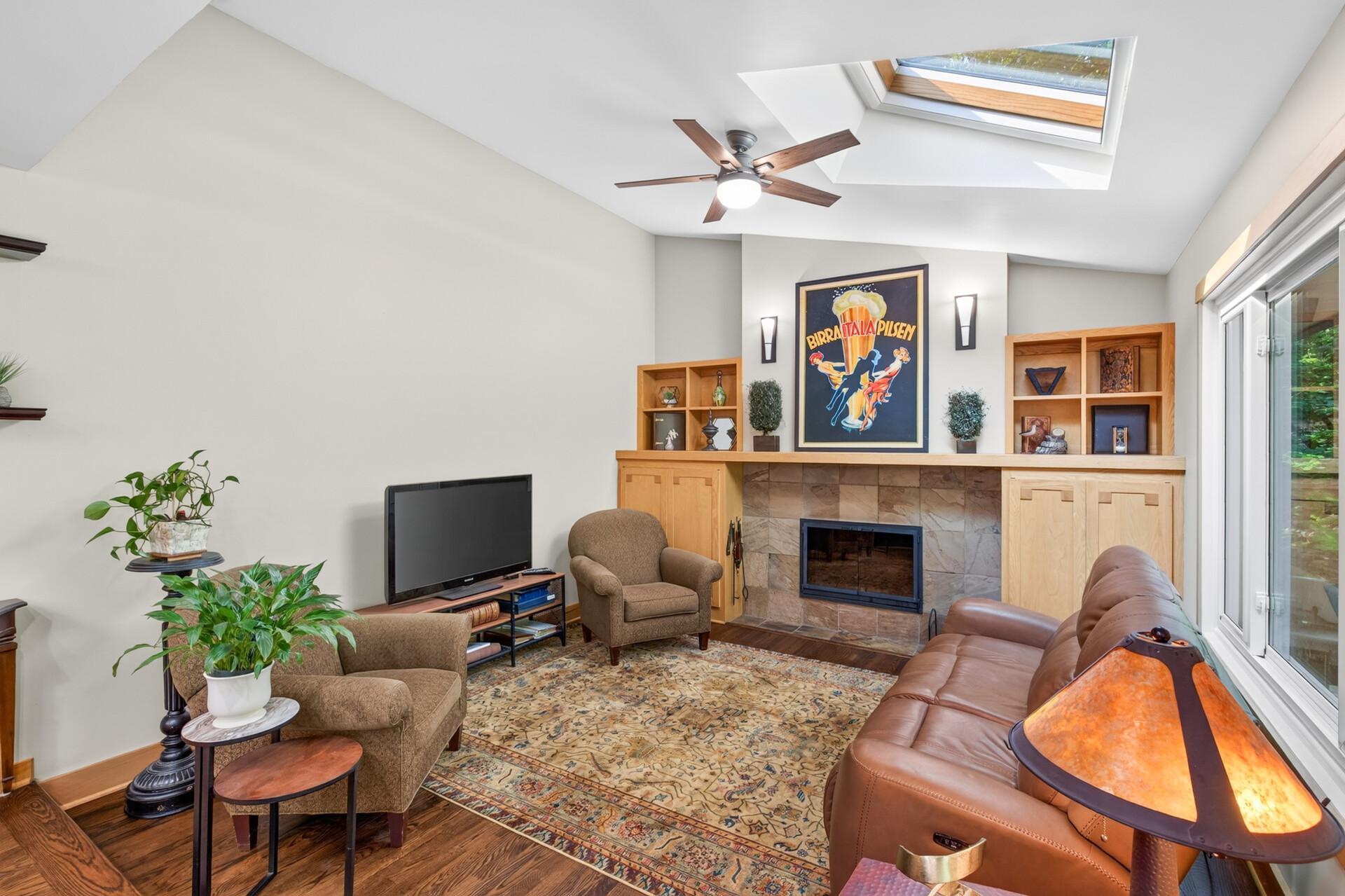 The vaulted hearth room offers a cozy setting for relaxing beside the wood burning fireplace and large skylight.