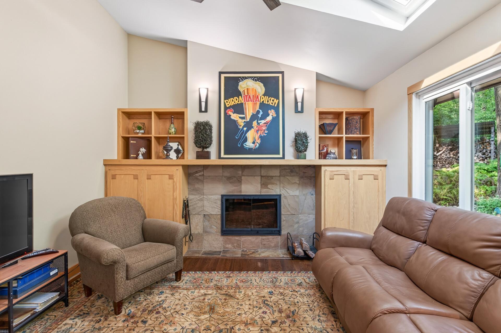 Vaulted ceilings, a skylight, custom built-ins, and a wood-burning fireplace make the hearth room an inviting place to linger.