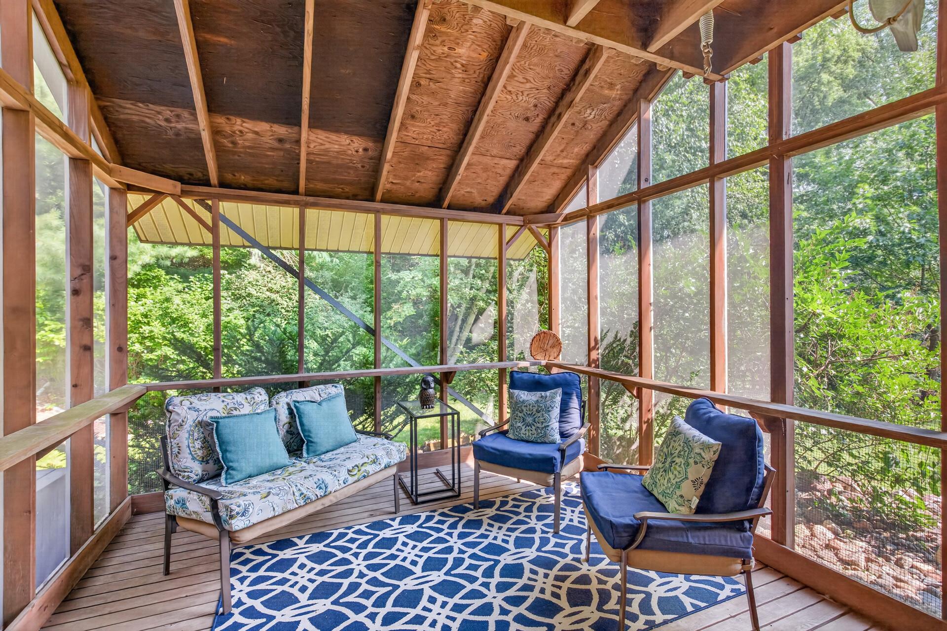 The screened three-season porch located off the 3rd level living space is ideal for reading, conversation, or enjoying a quiet evening.