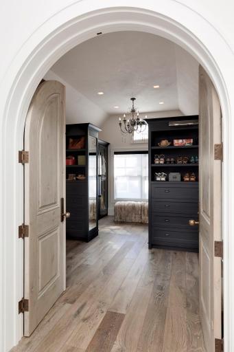 Primary suite entrance to the custom walk in closet with custom glass closet doors