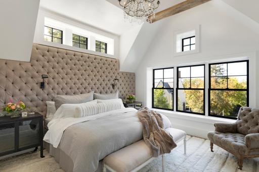 Open and light and bright primary suite bedroom with vaulted ceiling.