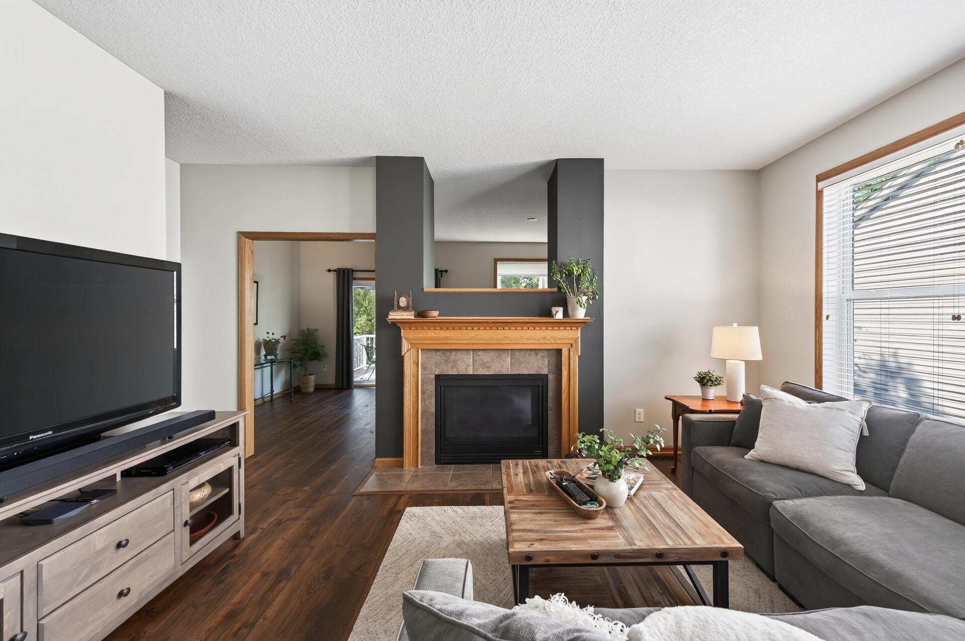 The double-sided gas fireplace with mantle is the showstopper of this generous living room; bringing warmth, character, and a natural gathering point to the heart of the home.