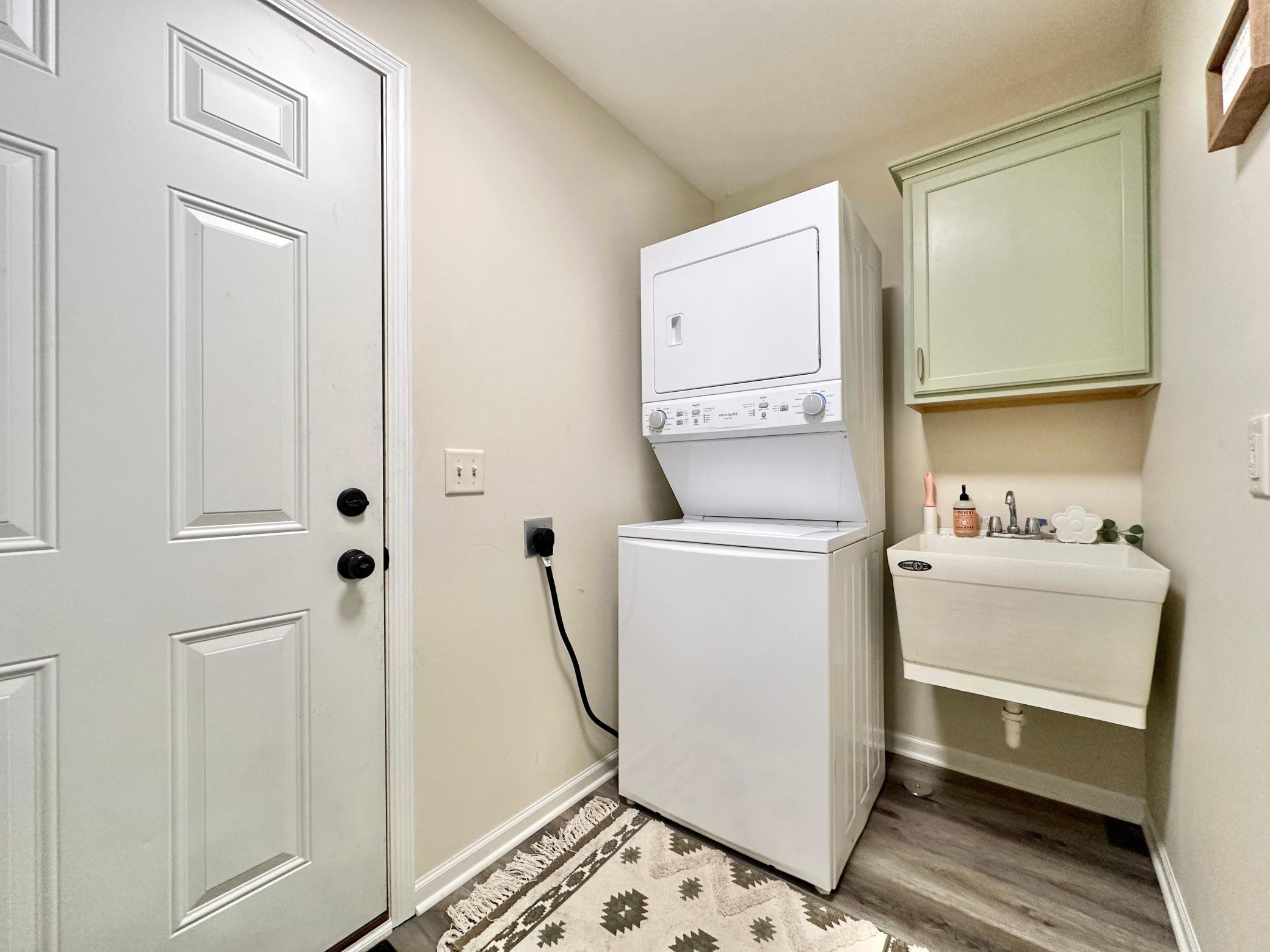 Back just off of the kitchen is the laundry room with stackable washer and drier. The wash tub and cupboard for detergents and added convenience.