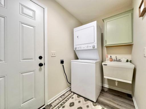 Back just off of the kitchen is the laundry room with stackable washer and drier. The wash tub and cupboard for detergents and added convenience.