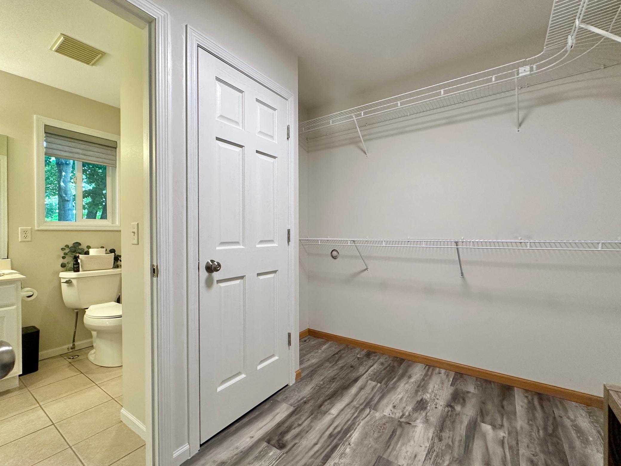 A angled look at the closet and a glimpse of the bath.