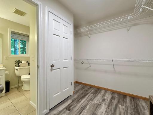 A angled look at the closet and a glimpse of the bath.
