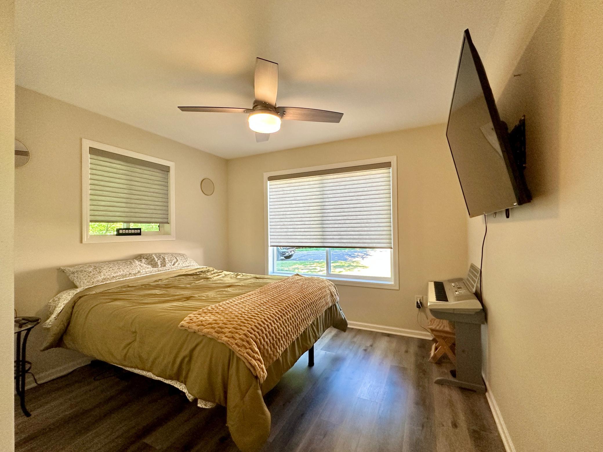 This front room of the house is warm and bright with two windows.