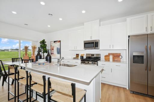 (Photo of model home, features will vary) A subway tile backsplash atop the 5-burner gas cooktop with an overhead microwave meets style with functionality
