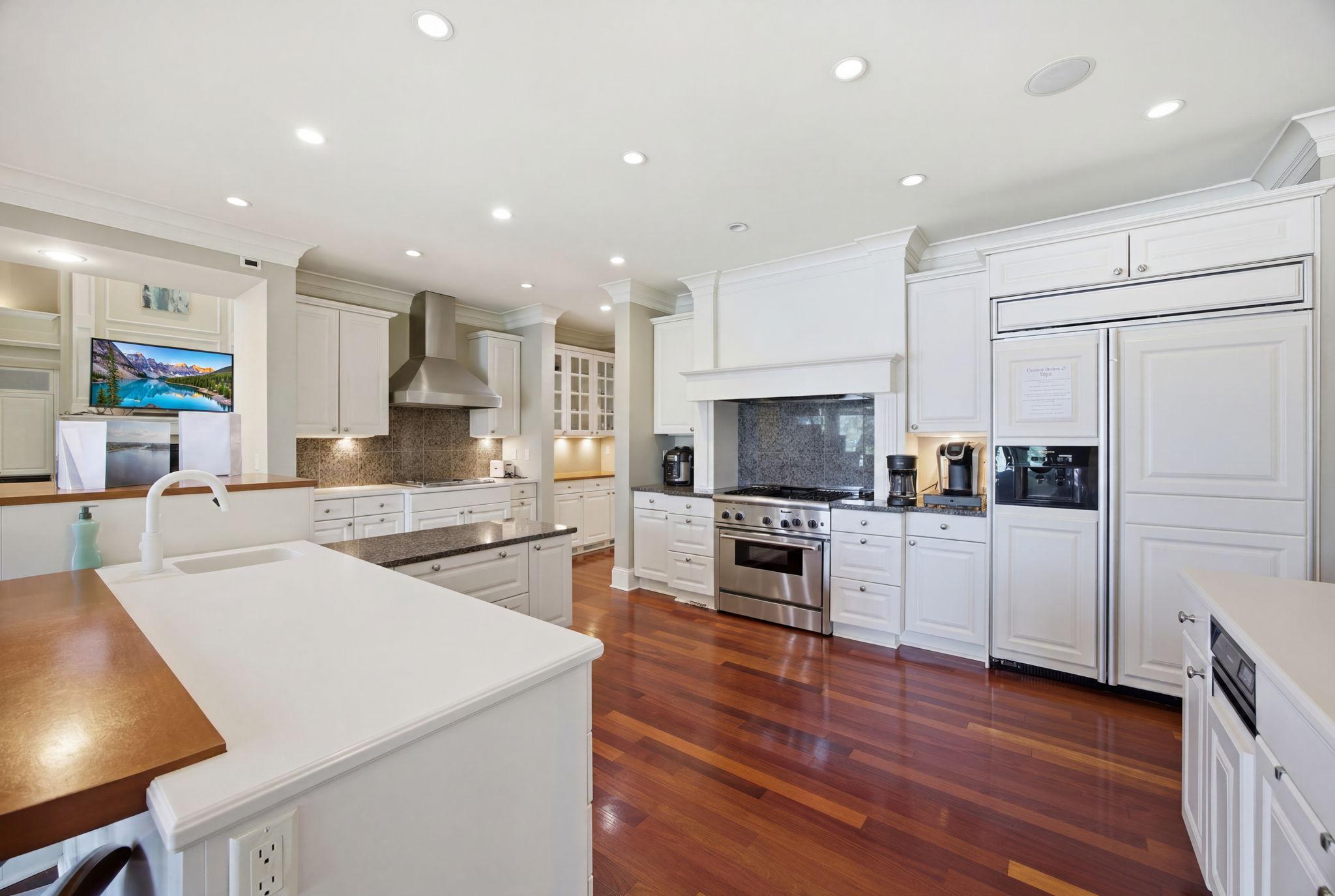 Designed to impress, the gourmet kitchen boasts expansive prep and workspace, dual ranges, a paneled built-in refrigerator, a spacious butler's pantry, and premium finishes