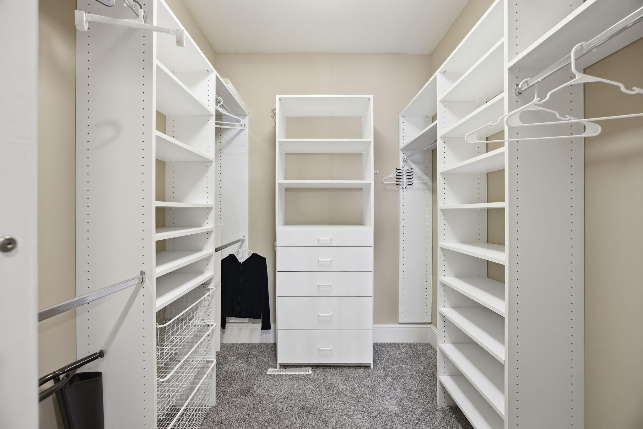 A spacious walk-in closet provides extensive shelving, drawers, and room to keep everything beautifully organized
