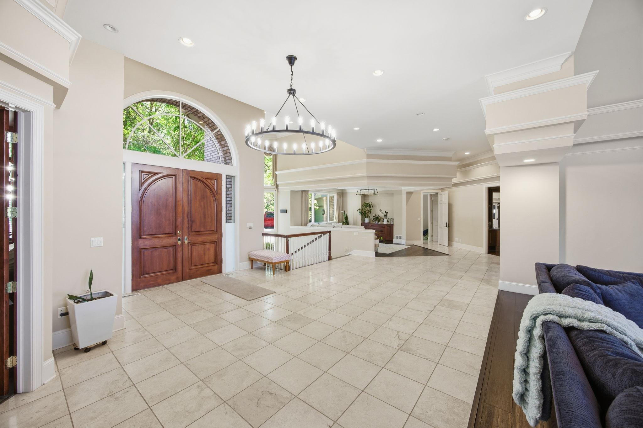 Step inside to a soaring, light-filled foyer where the arched entry and elegant millwork set a graceful tone