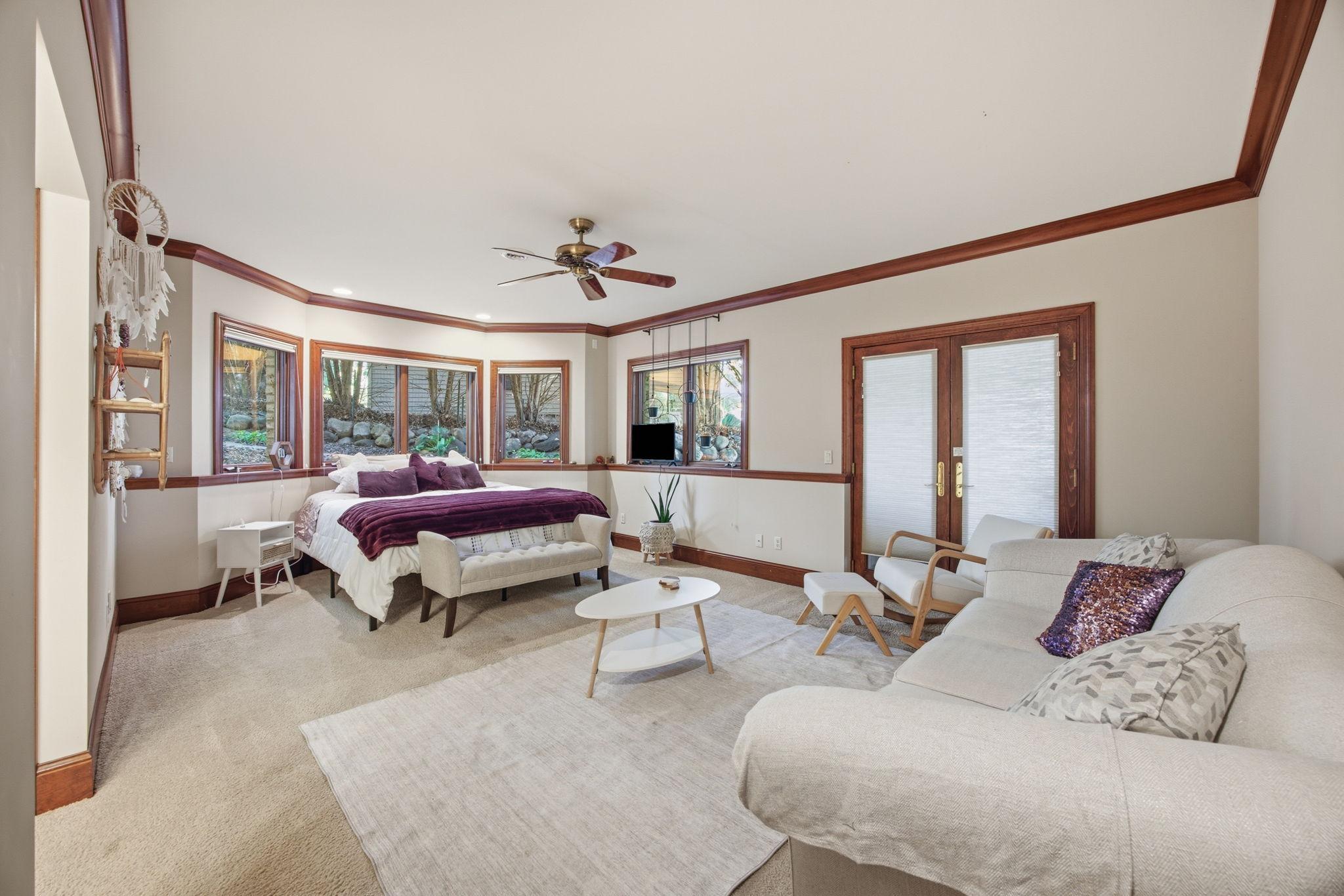 A generous lower level bedroom with a dedicated sitting area offers comfort, flexibility, and peaceful views