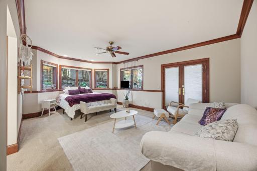 A generous lower level bedroom with a dedicated sitting area offers comfort, flexibility, and peaceful views