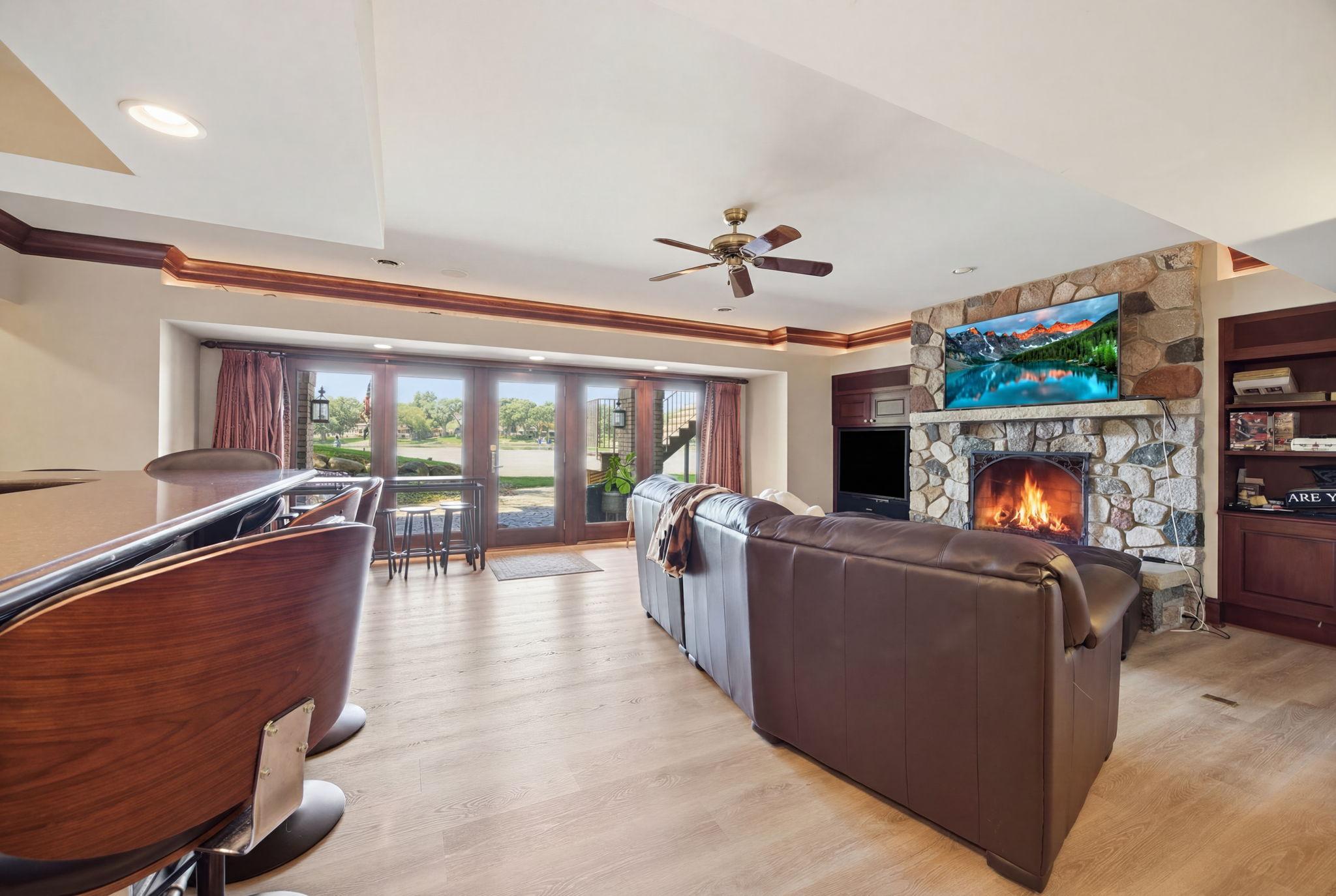 The walkout-level family room invites everyone to gather around the stone fireplace with the lake just beyond
