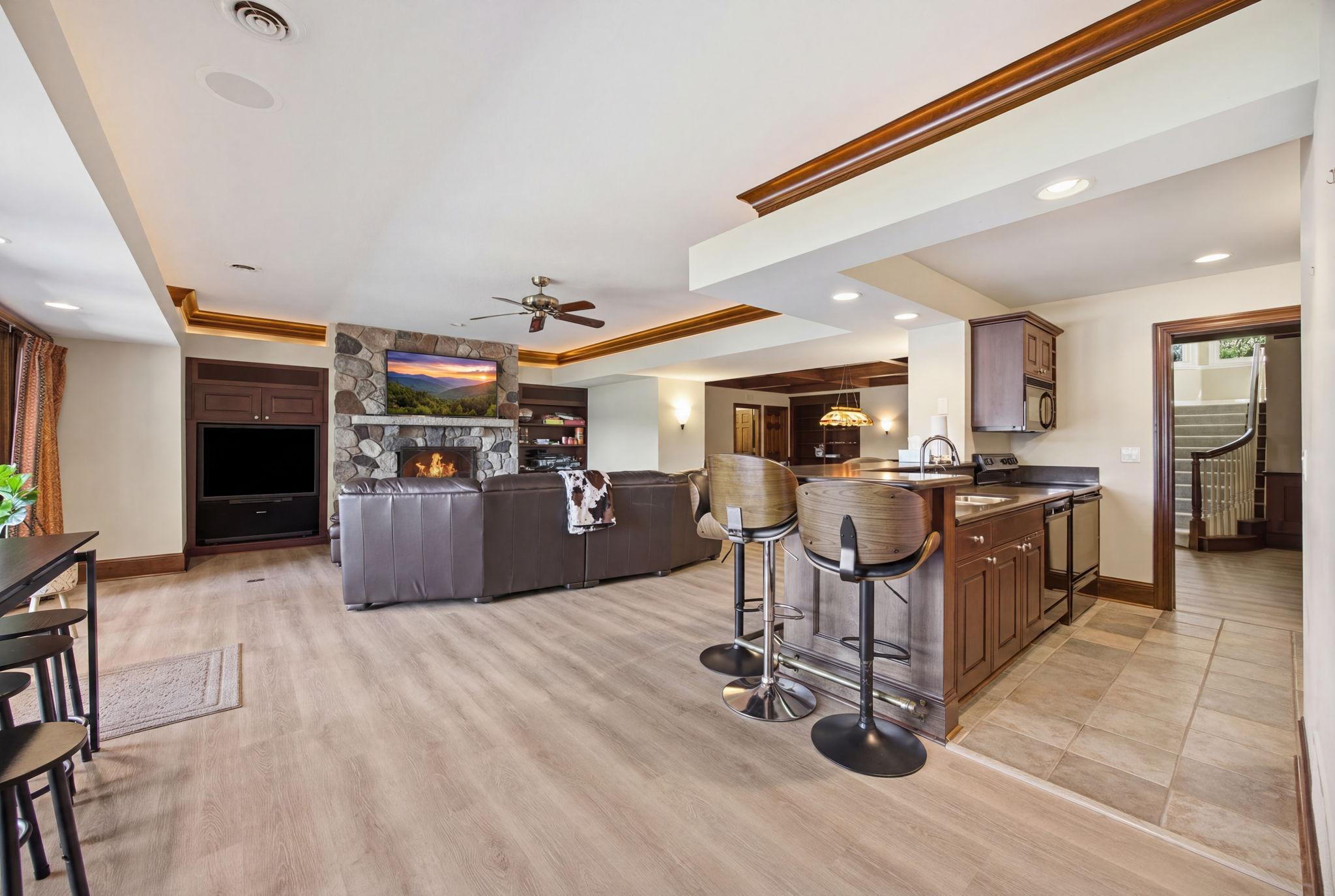 An open lower-level layout connects the family room, fireplace, and bar for effortless entertaining