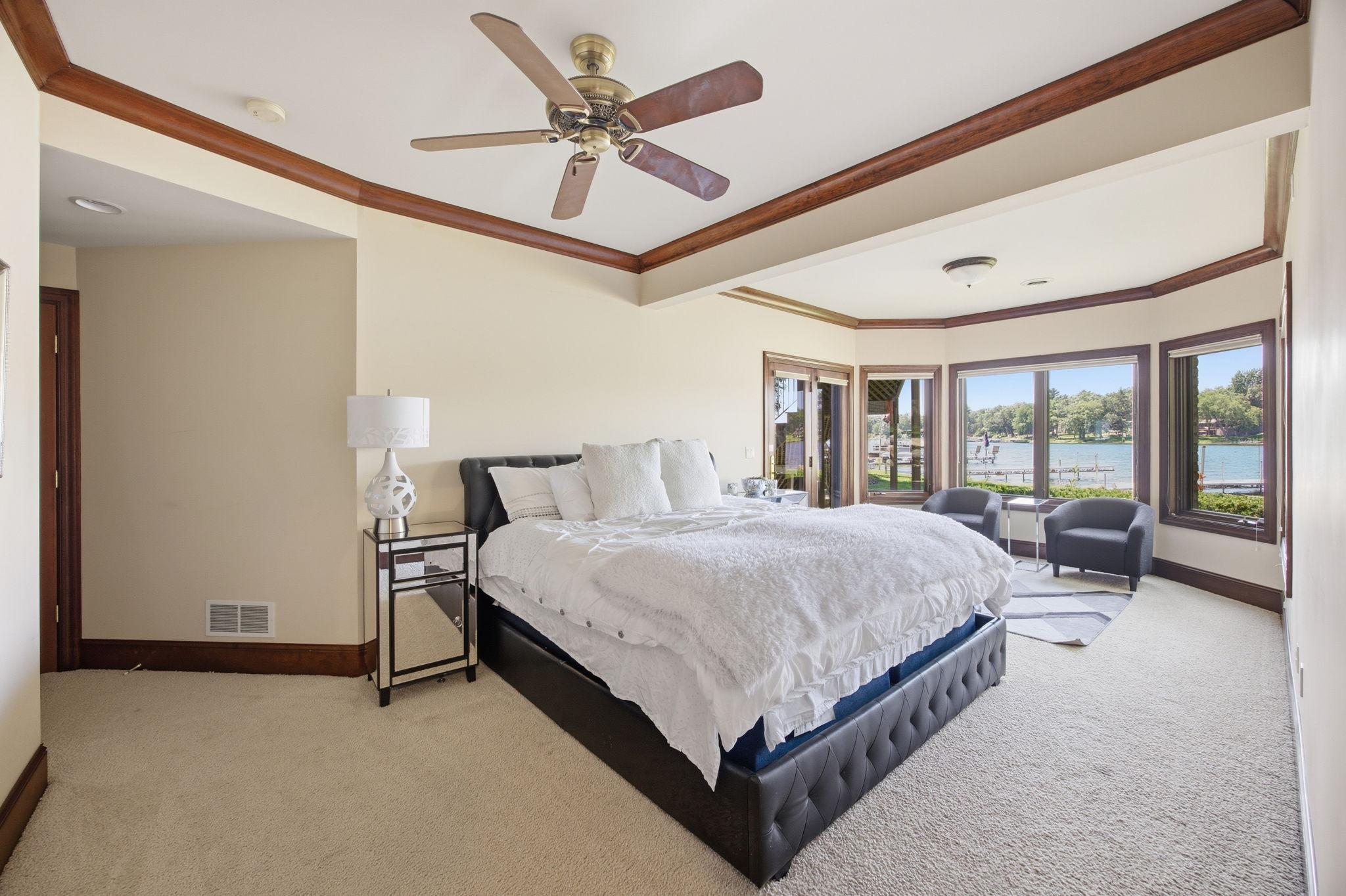 Wake to sparkling water views from this spacious lake-facing lower level bedroom 3 with a cozy sitting area