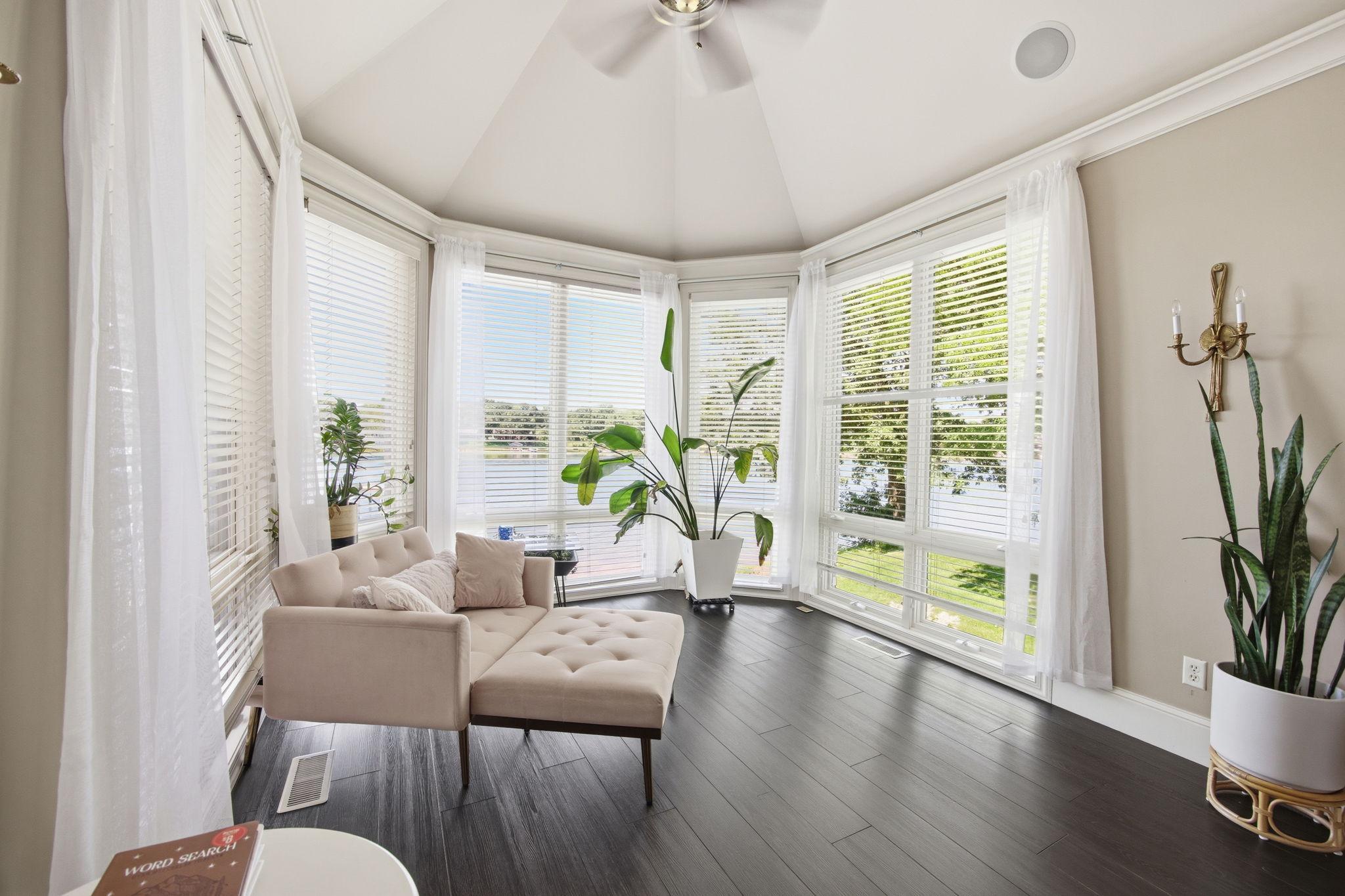 The sun-filled primary suite sitting area creates a serene escape, offering the perfect place to enjoy morning coffee and picturesque lake views