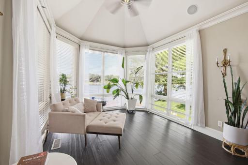 The sun-filled primary suite sitting area creates a serene escape, offering the perfect place to enjoy morning coffee and picturesque lake views