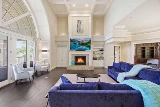 The vaulted living space is highlighted by a stunning fireplace and custom built-ins, creating a warm and inviting focal point