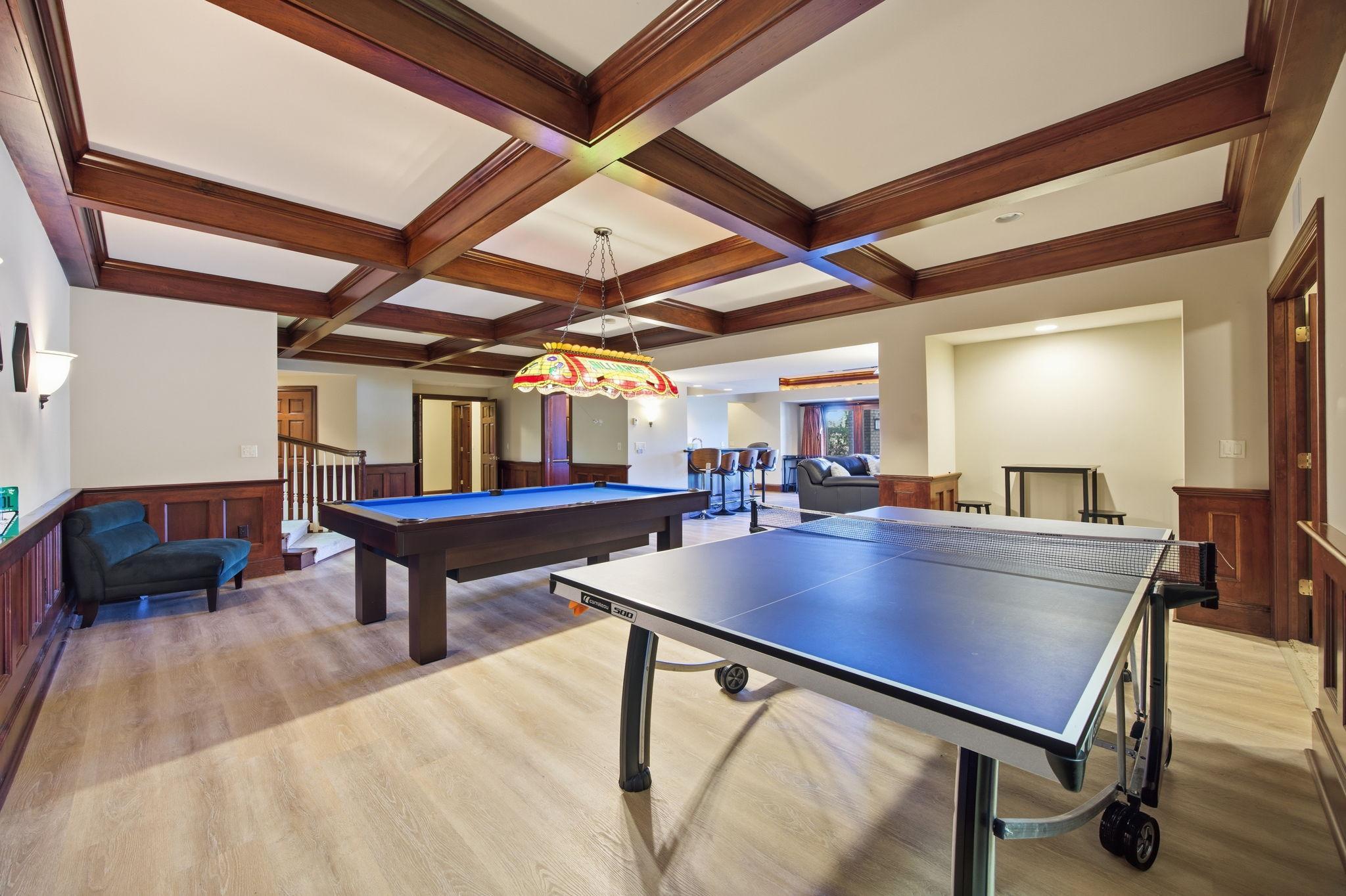 Lower level game room is made for memorable evenings, with rich wood details and space for multiple games