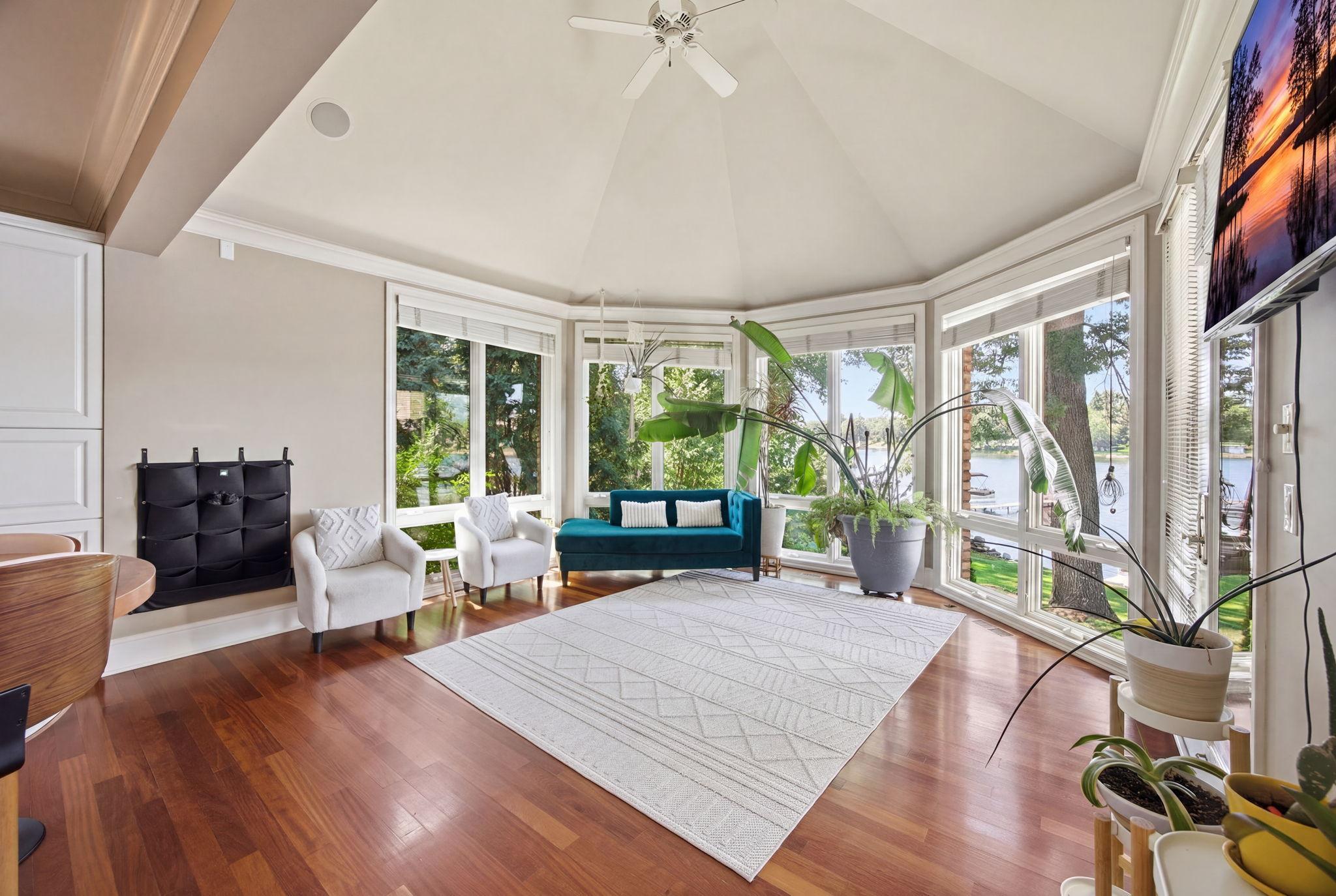 The light-filled sunroom feels wonderfully connected to the outdoors through walls of windows