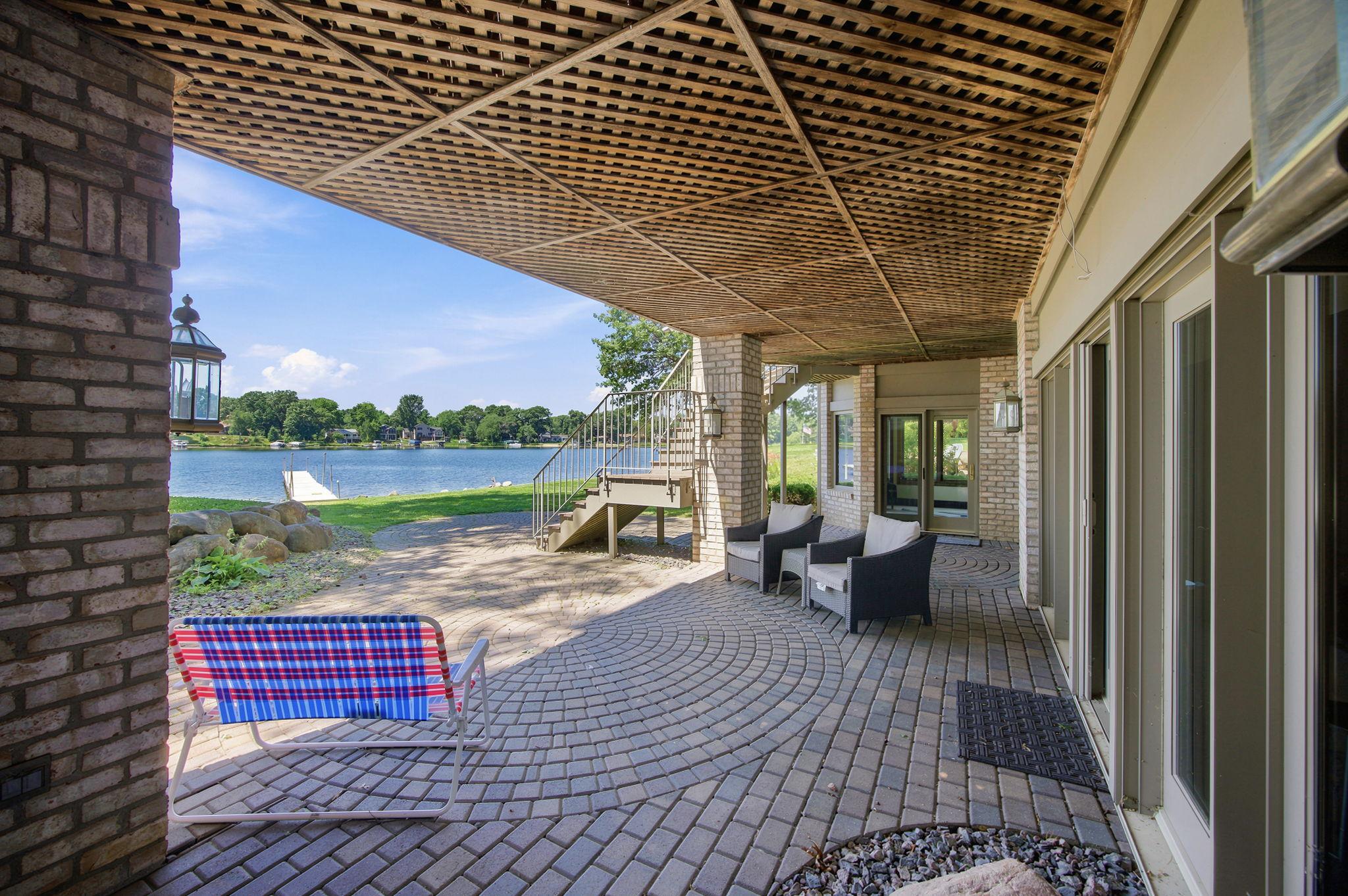The covered paver patio creates a shaded outdoor retreat with easy access to the lake