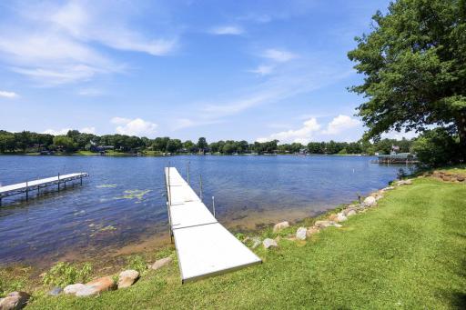 The dock extends into sparkling blue water, offering a front-row seat to lake living
