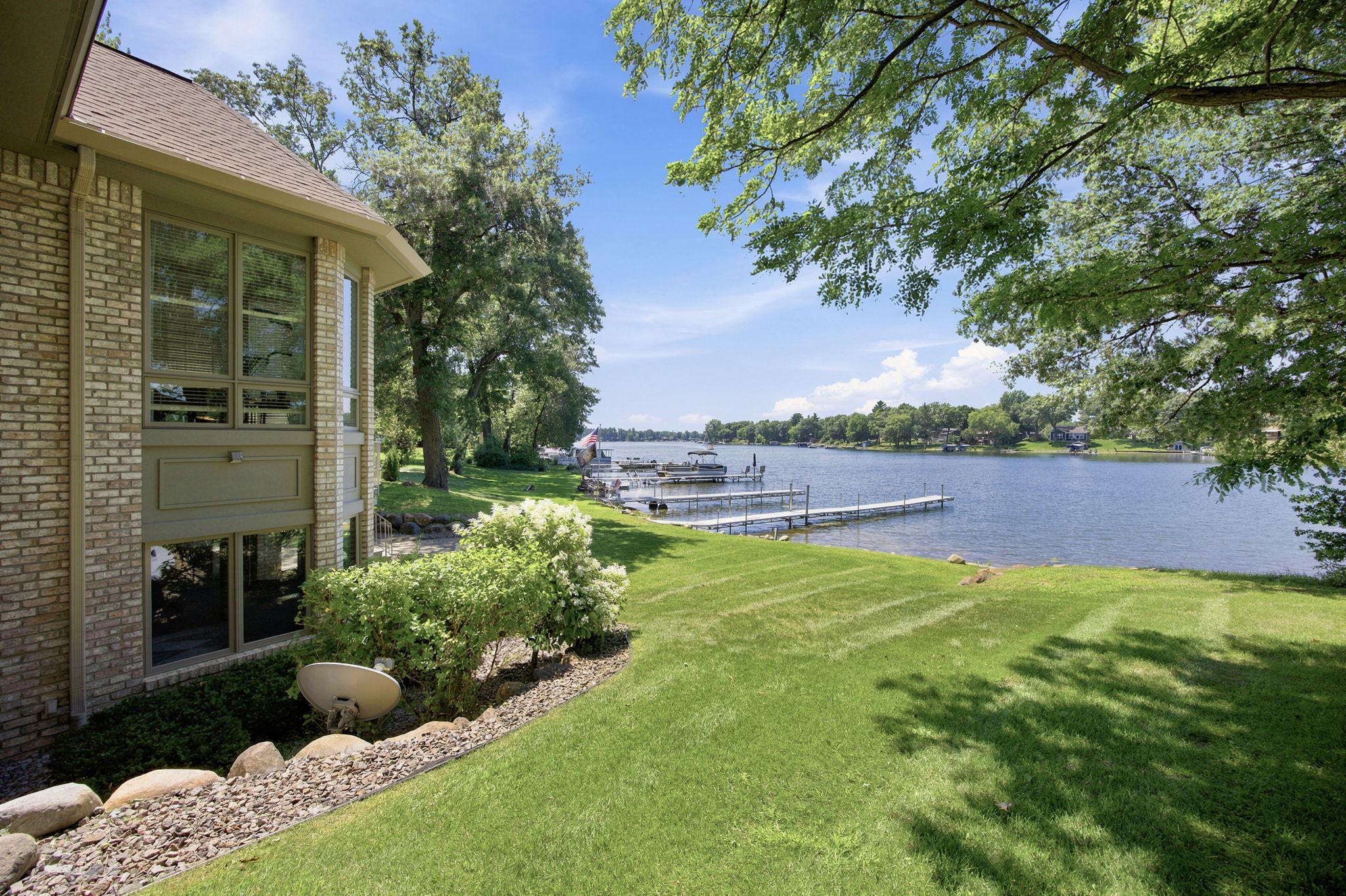Lush landscaping and a level lawn create a lovely transition from the home to the shoreline