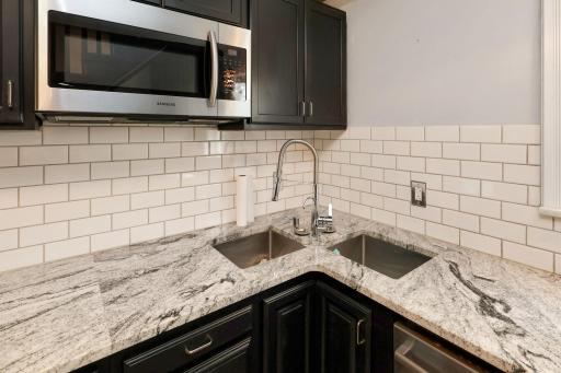 Granite countertops, tile backsplash, double sink, and stainless steel appliances.jpg