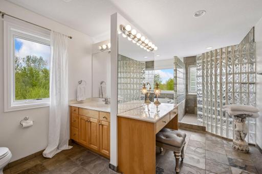 Primary bathroom features dual sinks, additional vanity area, and a separate tub and shower