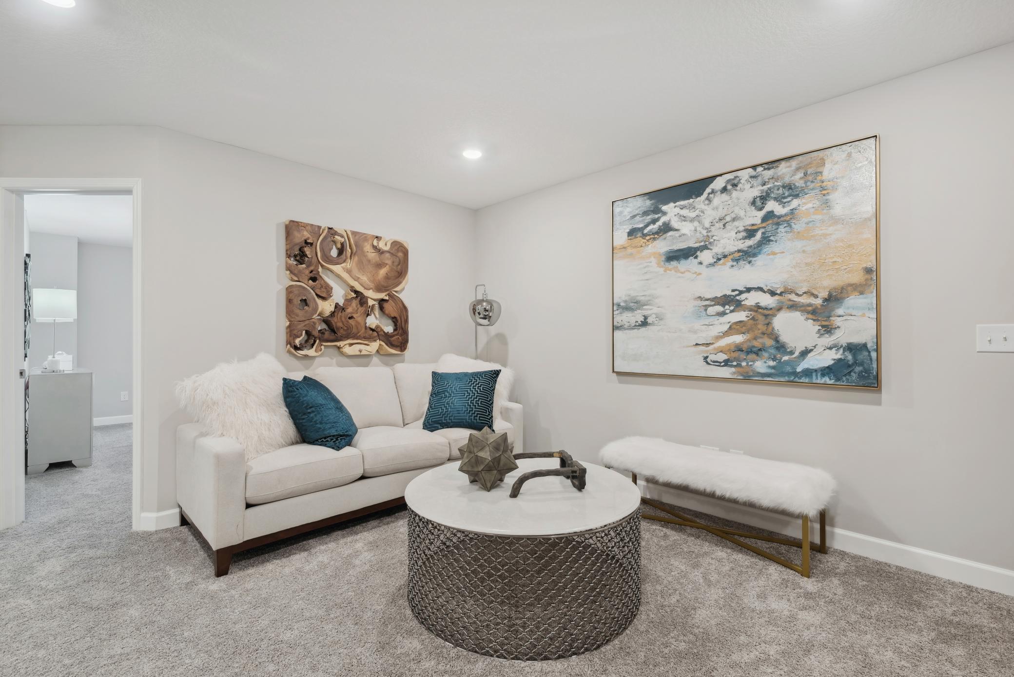 (Photo of a decorated model, actual homes finishes will vary) Located on the upper level, this perfectly sized living space has enough room for a desk, television and seating for all. Plus, it is just steps away from the three bedrooms.