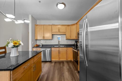 Kitchen with full-size stainless refrigerator and granite-topped island