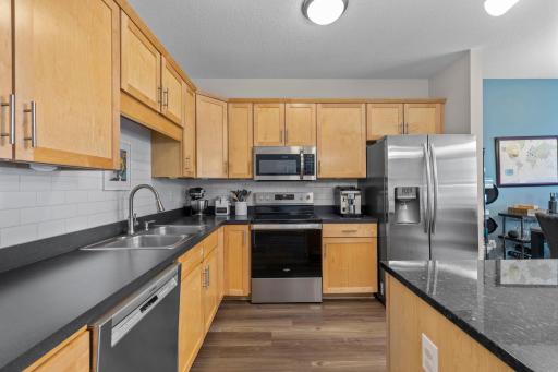 Kitchen with granite counters, subway tile backsplash, and a new stainless dishwasher