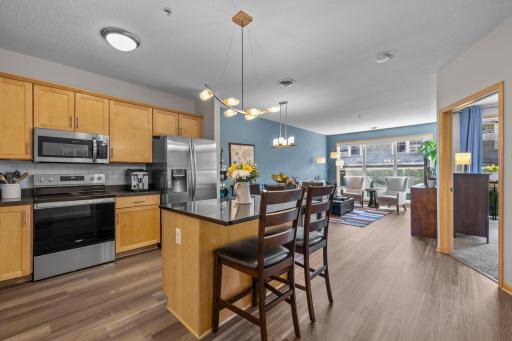 Open-concept kitchen with granite counters and stainless appliances, flowing into the dining and living areas