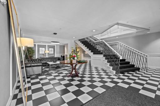 Elegant building lobby with classic checkerboard tile and grand staircase