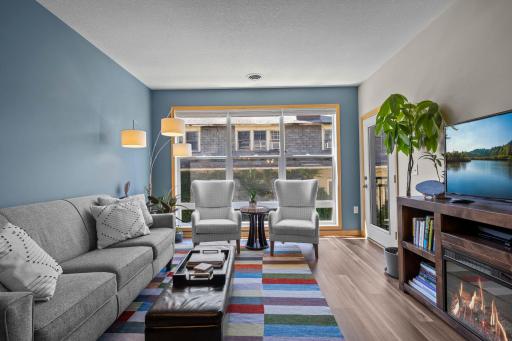 Photo for 301 Oak Grove Street, 308, Minneapolis, MN 55403 - listing #7108803 Sunny living room with floor-to-ceiling windows, new LVP flooring, and a cozy gas fireplace